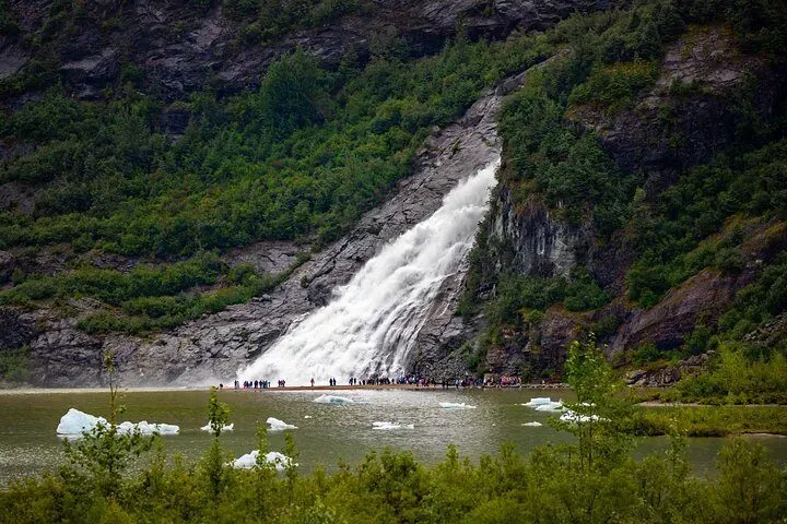Nugget Falls thundering down beside Mendenhall Lake on a Mendenhall Glacier waterfall and whale watching tour in Juneau